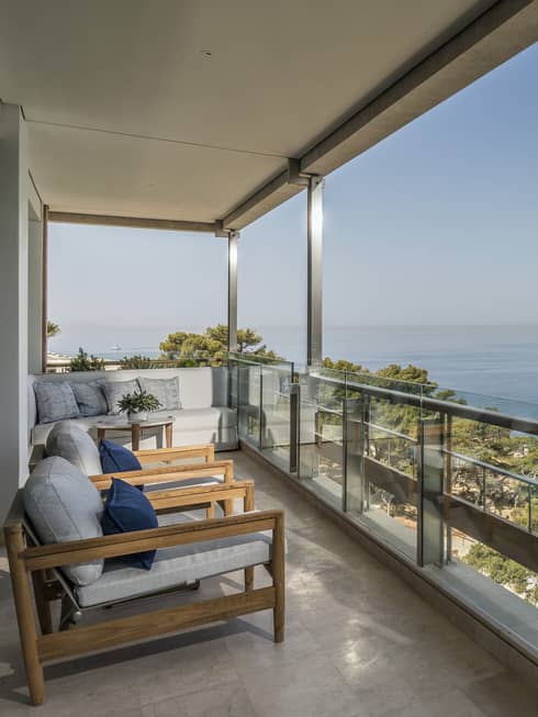 Arion Sea View Suite Balcony with row of lounge chairs, view of boats on the Mediterranean Sea