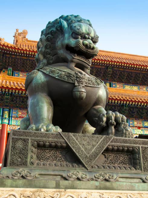 Large guardian lion statue in front of Chinese temple