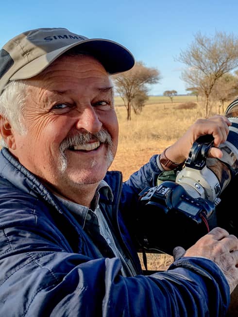 Portrait photo of resident wildlife photographer Rick Collins holding camera