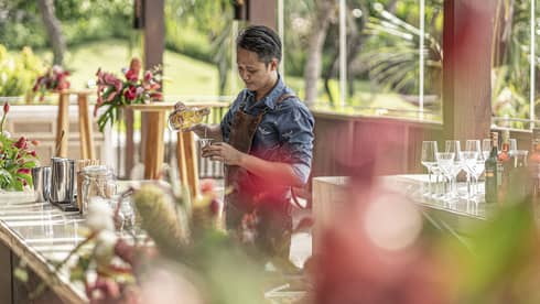 Bartender mixes drink at outdoor bar