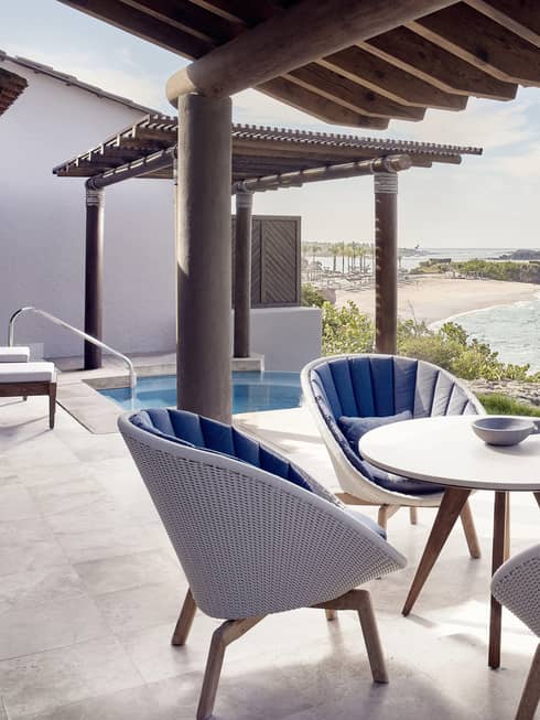 Outdoor terrace, dining table with four wicker chairs, plunge pool, ocean view