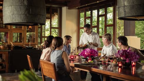 Chef presents basket with fresh hot peppers to guests at large private dining table