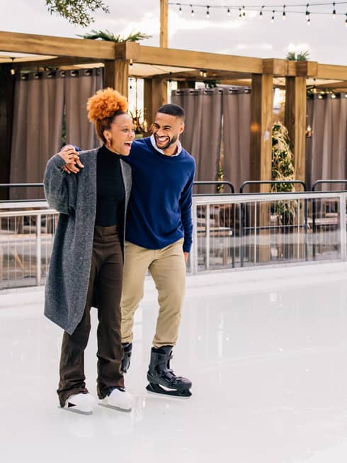 A man and woman iceskating.
