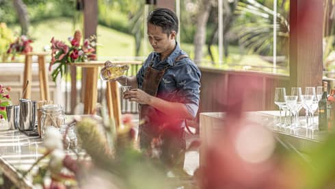 Bartender mixes drink at outdoor bar