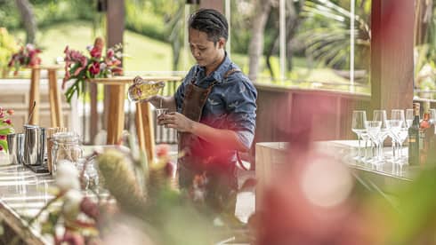 Bartender mixes drink at outdoor bar