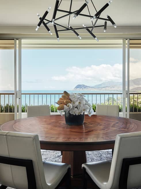 White chairs at large wood dining table under modern black light