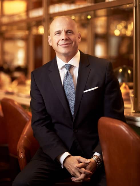 Portrait photo of Four Seasons Hotel President, Worldwide Hotel Operations Christian Clerc at bar wearing suit