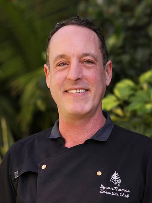 Portrait photo of Executive Chef Byron David Thomas wearing black uniform
