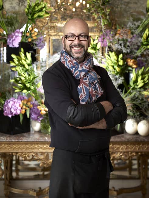 Portrait photo of florist Serge Marzetta in front of flowers