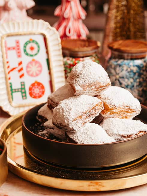 A bowl of desserts with a bowl of sprinkles beside it and festive d�cor.
