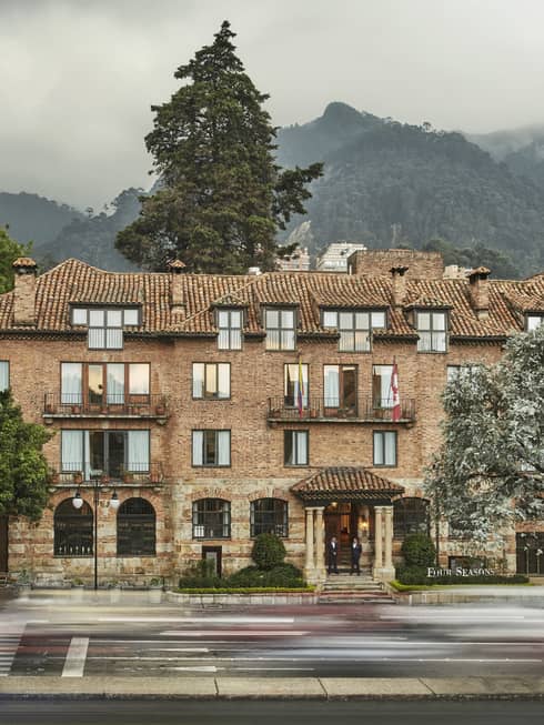 Exterior of historic brick Four Seasons Hotel Bogota, Casa Medina hotel, mountain in background