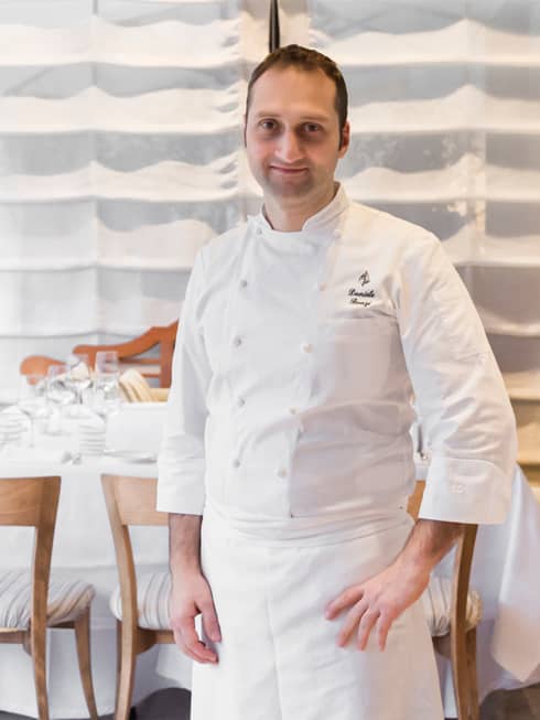 Portrait photo of Executive Pastry Chef Daniele Bonzi standing in white uniform