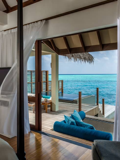 Sheer white curtain blowing in breeze by open door to Water Villa patio