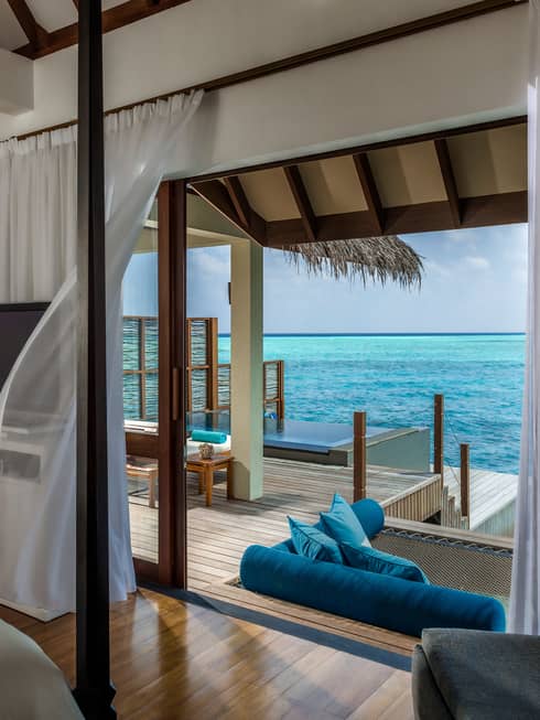 Sheer white curtain blowing in breeze by open door to Water Villa patio
