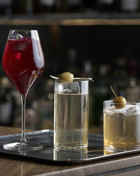 Three different cocktails on a bar tray