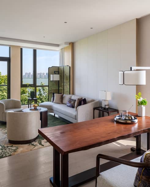 Luxury hotel suite with living room and natural wood dining table, views of Jinji Lake and Suzhou city ? Four Seasons Hotel Suzhou