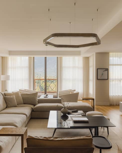 Modern living room of a mountain resort private residence, featuring large sectional sofa and fireplace