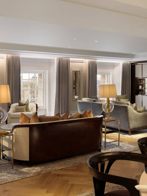 Large neutral living room with two seating vignettes flanked by lamps on side tables