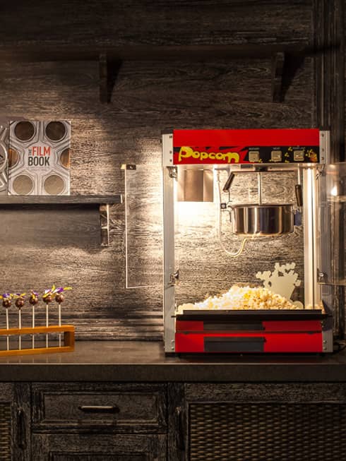 Popcorn machine, candy and film books on shelf in dark room