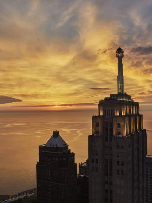 The tops of several buildings and Lake Michigan at sunset
