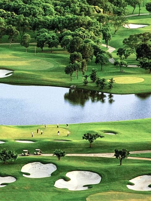 Golf greens with sand traps, large pond, trees
