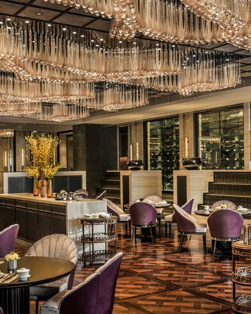 Jin House purple chairs under dining tables under full ceiling with teardrop-shaped crystals