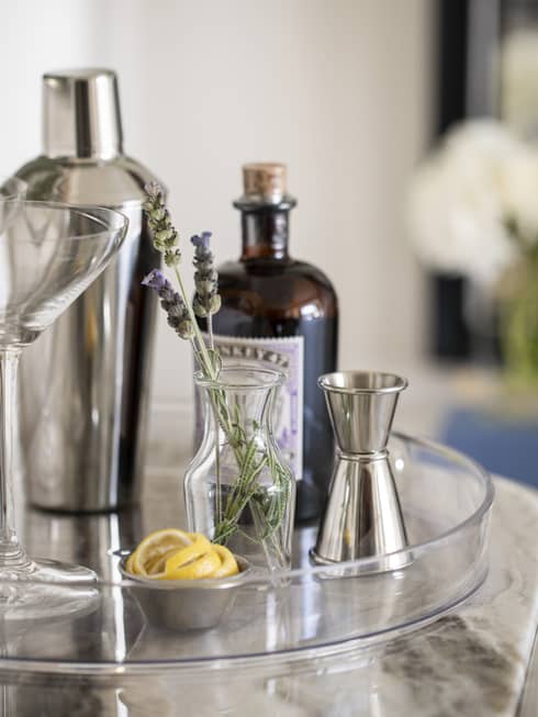 Martini tray with shaker, two martini glasses, a cup of sliced lemons, and a vase with lavender sprigs