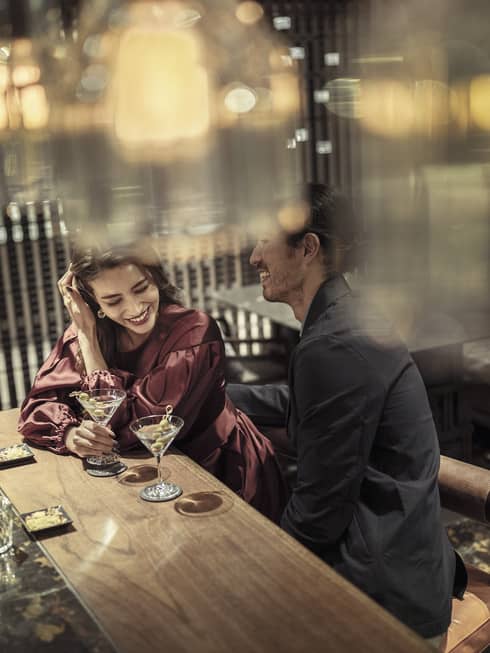 Laughing couple enjoys martinis at The Lounge 