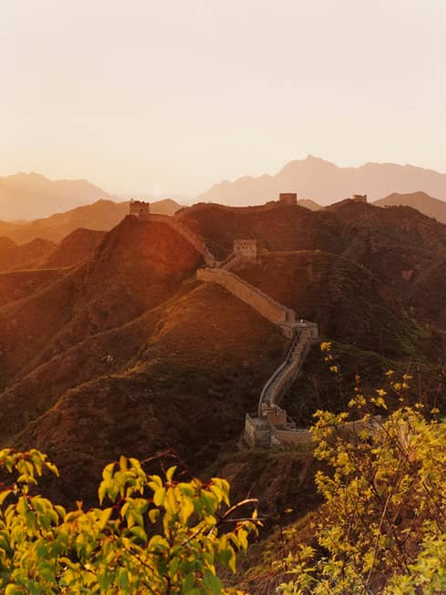 Sunset over mountain, trees with Great Wall of China along side
