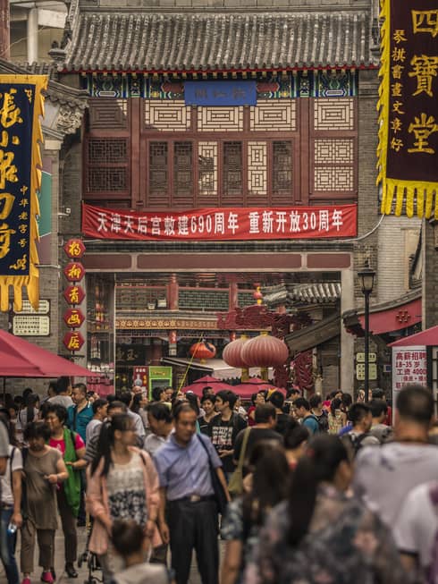 People walk through crowds on busy Tianjin street
