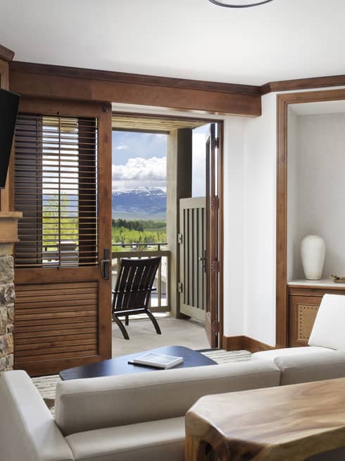 Living room with sofa, fireplace, wall-mounted TV and balcony