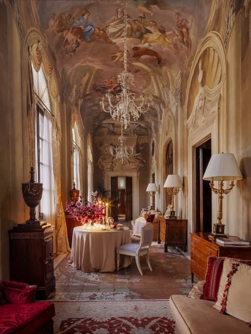 Elegant historic salon with rich fabrics and arched frescoes