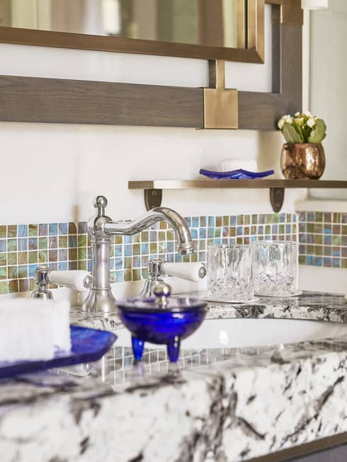 Close-up of a marble bathroom vanity with mosaic tiles lined on the wall