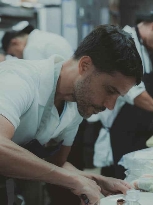 Chef Virgilio Mart�nez wearing an apron and cooking in the kitchen.