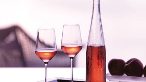 Tray with two wine glasses and glass bottle with rosee 
