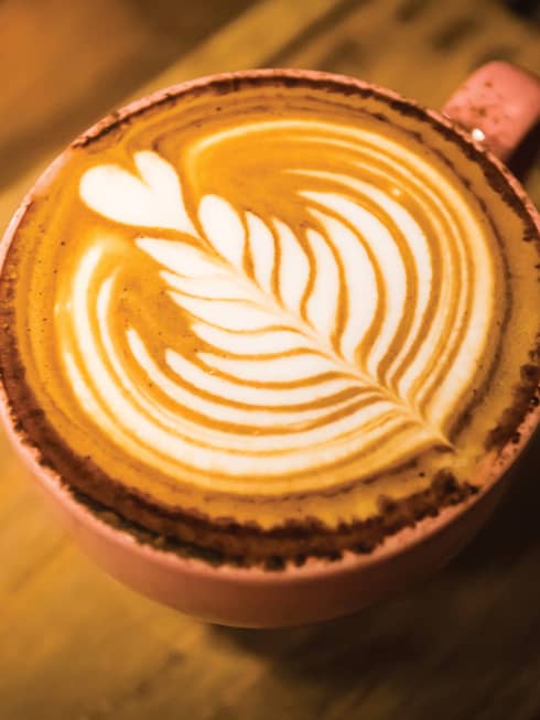 Close-up of latte coffee with flower design in foam