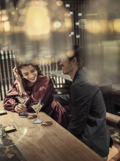 Laughing couple enjoys martinis at The Lounge 