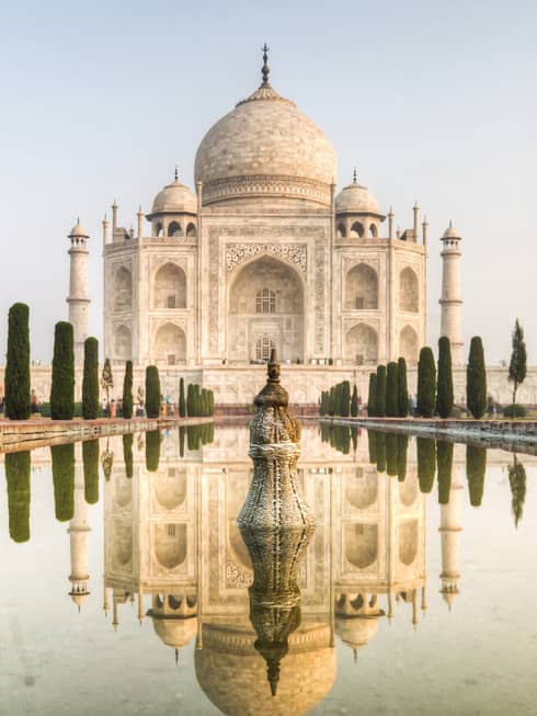 Clear water mirrors the reflection of the Taj Mahal