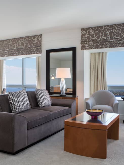 Grey sofa, armchairs in corner suite with large windows