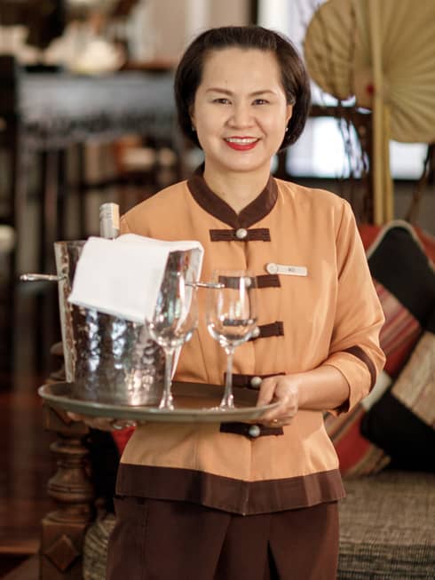Miss Moo Chaweewan Promma holds tray with two empty wine glasses, steel bucket
