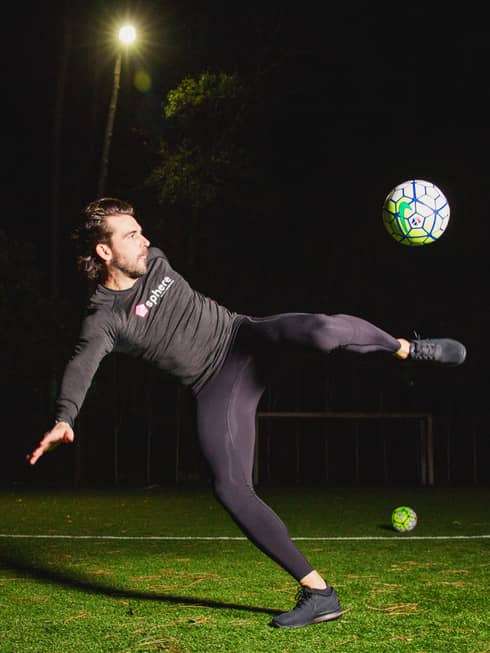 POWA by sphere session, Michael Chabala kicks soccer ball in mid-air on field with multiple balls at night
