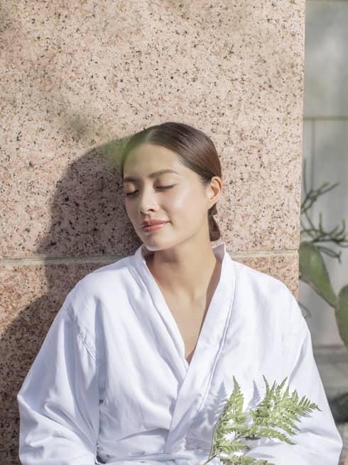 A woman in a spa robe enjoying the afterglow of a massage at the Four Seasons Hong Kong Spa.