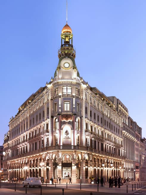 Four Seasons Hotel Madrid historic building exterior with lights at night