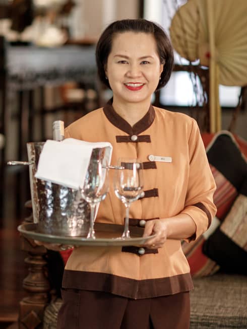 Miss Moo Chaweewan Promma holds tray with two empty wine glasses, steel bucket