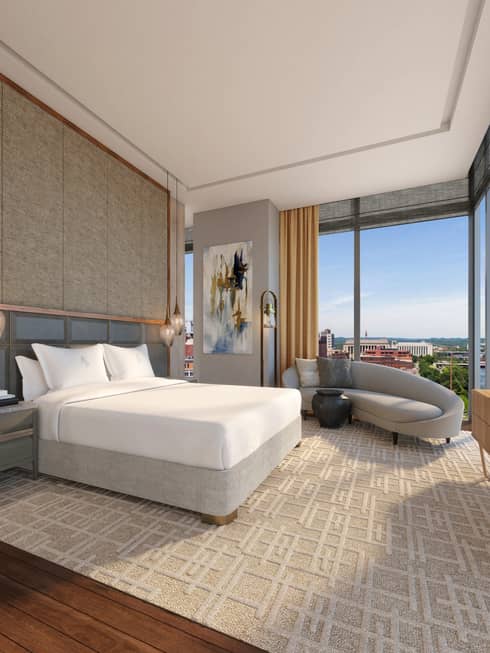 Hotel bedroom with king bed, chaise and corner windows
