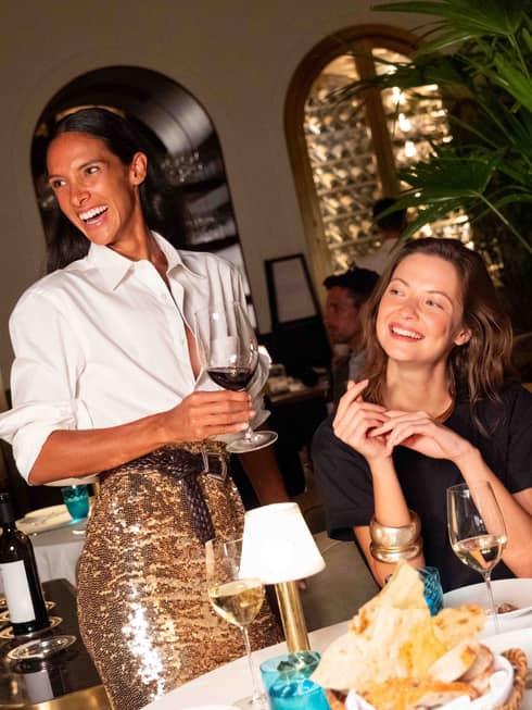 A group of people gathered at a dining table and smiling at one another