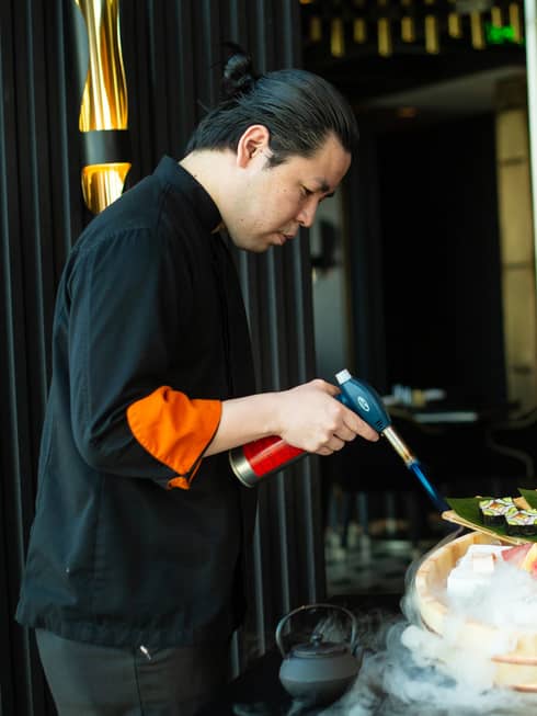Chef Yonaha uses a torch to put the finishing touches on a signature dish