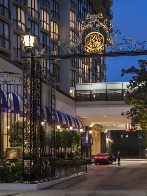 A gate with a golden symbol on top leading to a hotel.