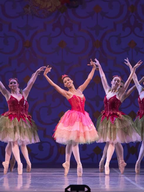 A group of female ballerinas dancing on stage.
