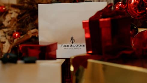 A gift card next to red and gold wrapped presents.